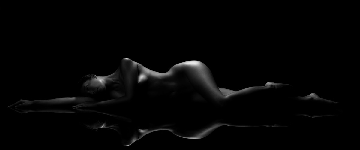 body of light image highlighting the female form laying down, and seeing her reflection in the mirror table