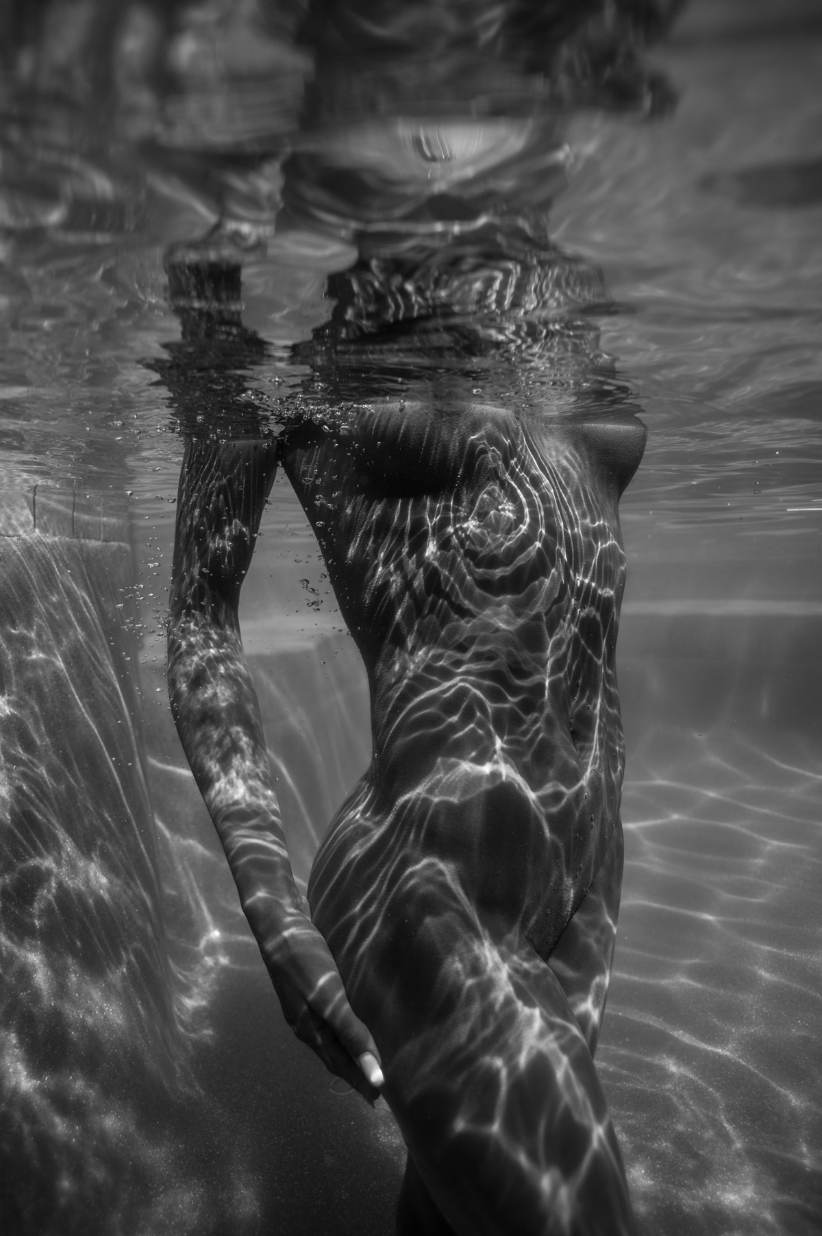 Underwater Fine Art image of nude female with water patterns on her body.